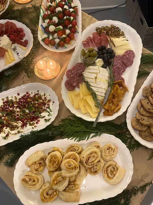 Spread of caprese skewers, whipped feta with pomegranate, charcuterie, pinwheels and cookies